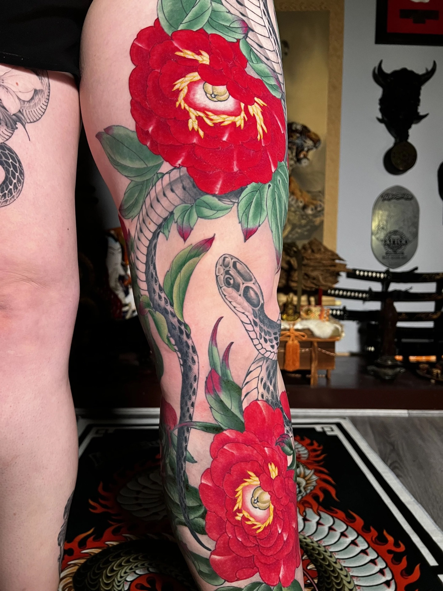 Camellia and snake colour leg tattoo by Levi Taylor
